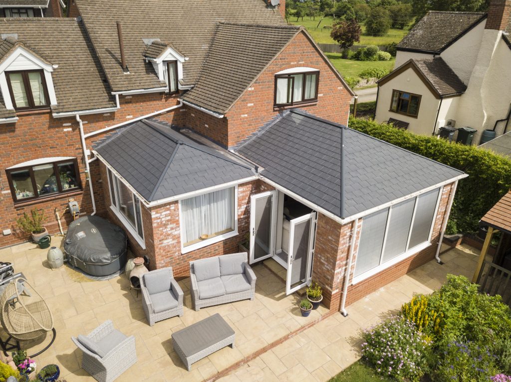 aerial view of replacement conservatory roof with garden furniture outside on patio